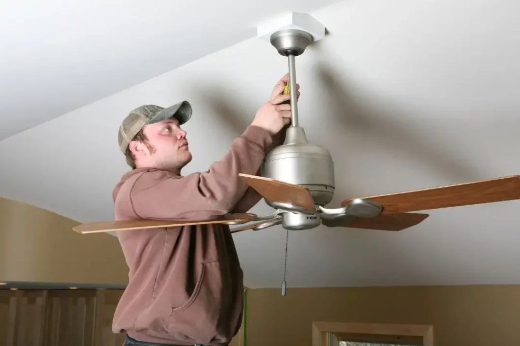 Electrician installing a ceiling fan
