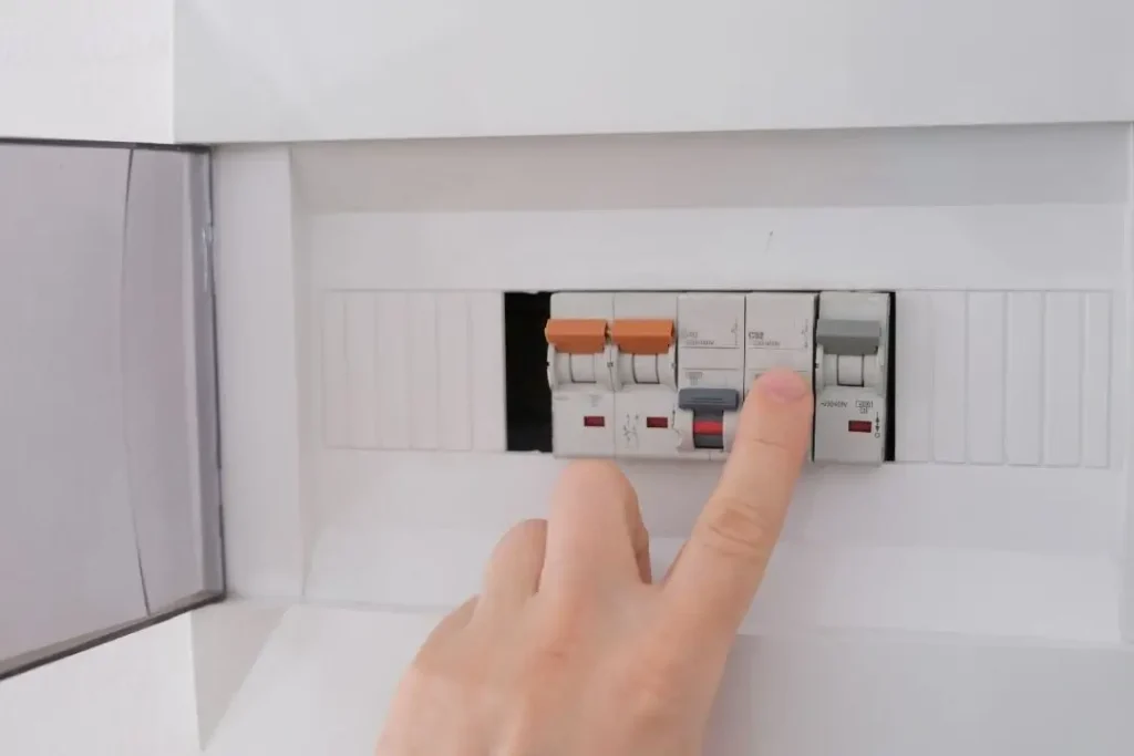 Person turning a tripped circuit breaker on